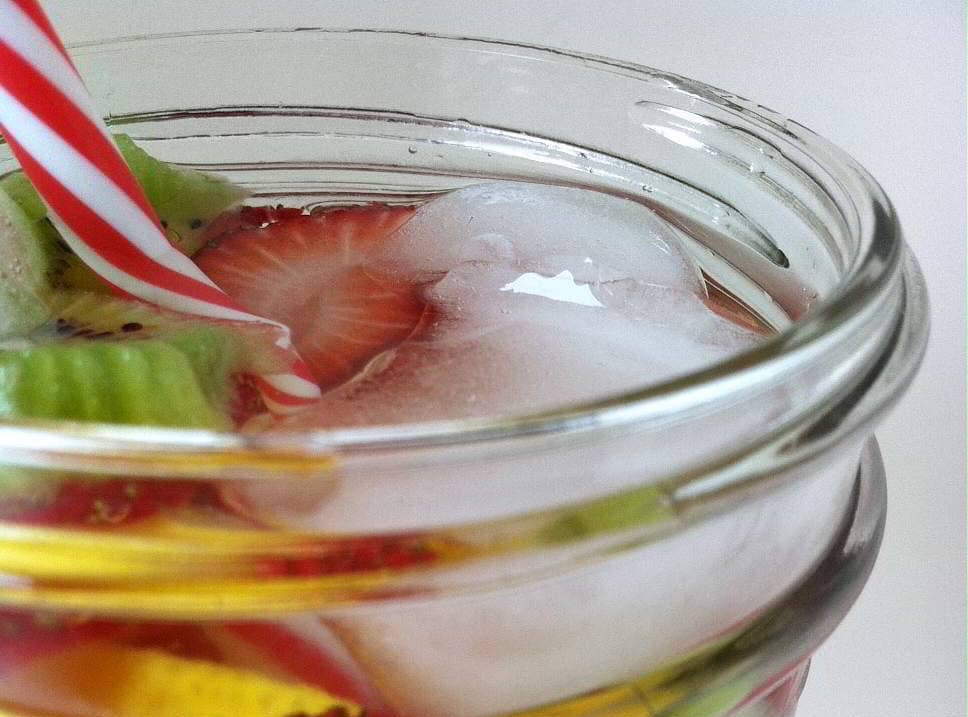 top view, close up image of water infused with fruit in a mason jar with a  straw
