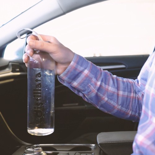 reusable distillata glass bottle in cup holder of car
