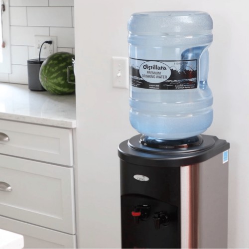 stainless steel water cooler with a bottle of Distillata 5-gallon water on top