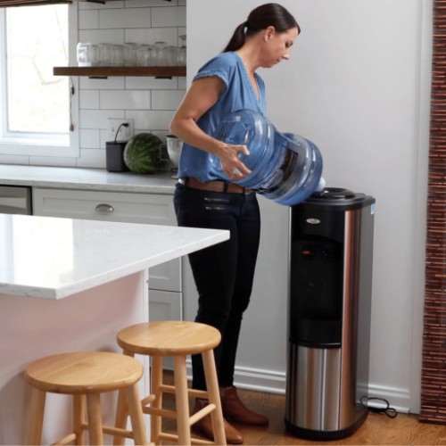 placing a 5-gallon water bottle on a stainless steel water cooler