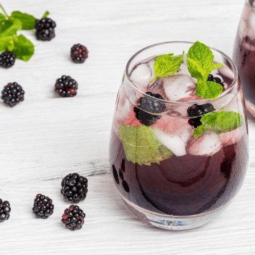 blackberry mint infused water in a small, clear glass