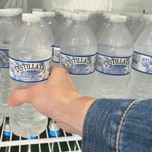 getting a bottle of Distillata spring water from the fridge