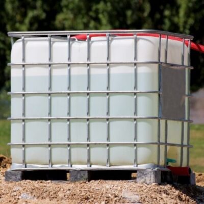 ibc water tote in metal cage in yard