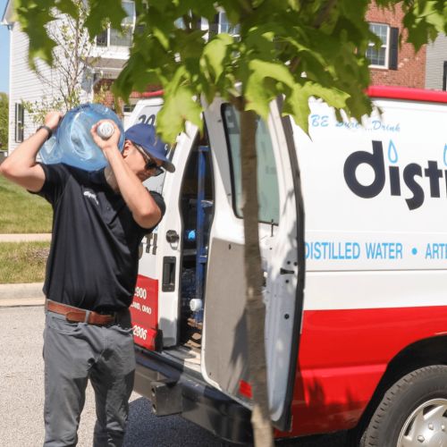 distillata driver unloading 5-gallon water bottle from van