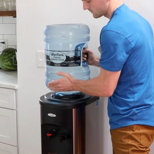 man loading a bottle on a Stainless steel hot and cold water dispenser