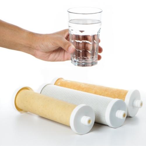 clear glass of water with three replacement water filter cartridges