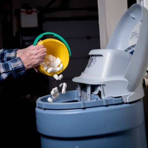 pouring salt into a water softener