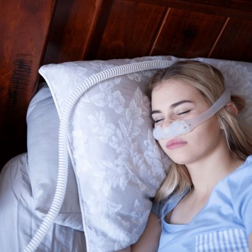 woman sleeping in bed with cpap mask on