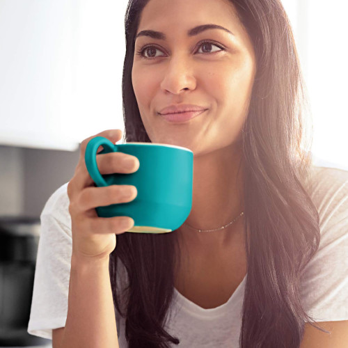 woman sipping coffee from a teal mug