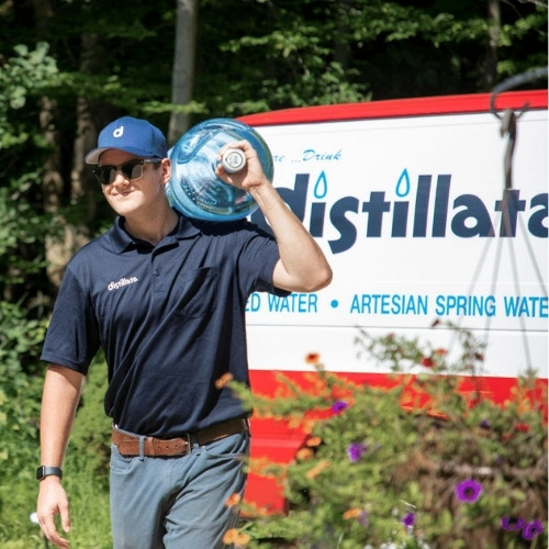 distillata water delivery driver carrying bottle on shoulder