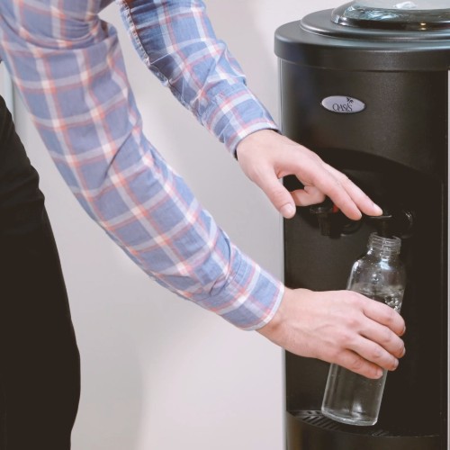 filling reusable distillata glass bottle from a black water cooler