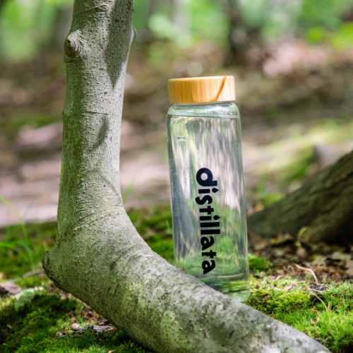clear distillata water bottle in woods