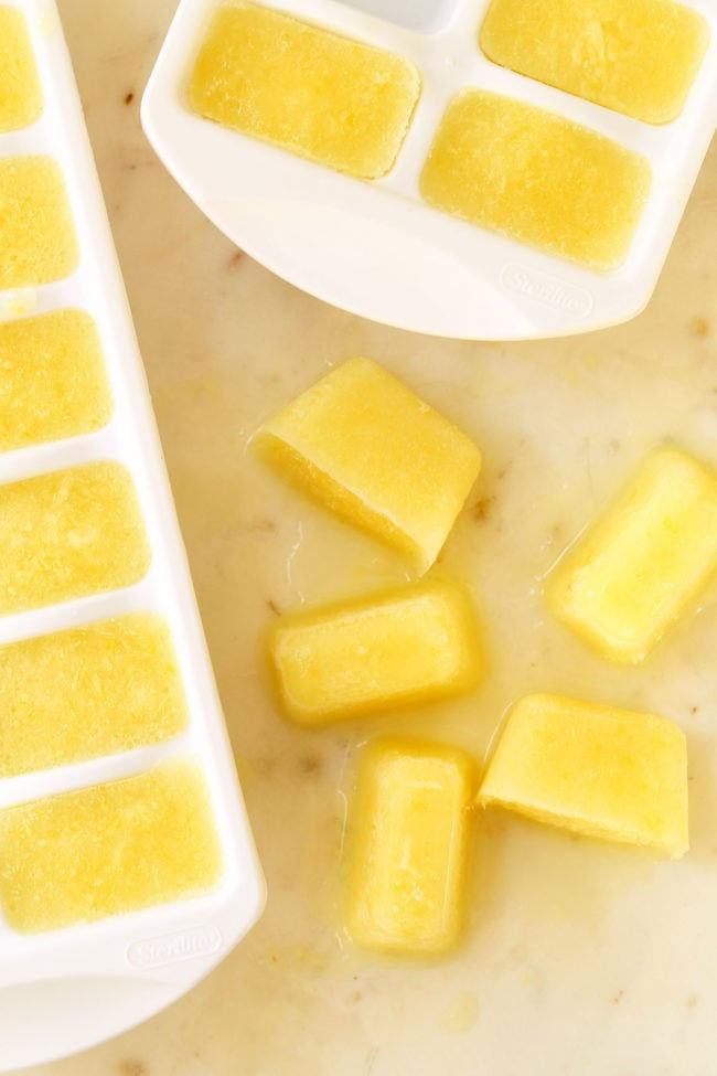 homemade lemon flavored ice cubes in a white ice cube tray