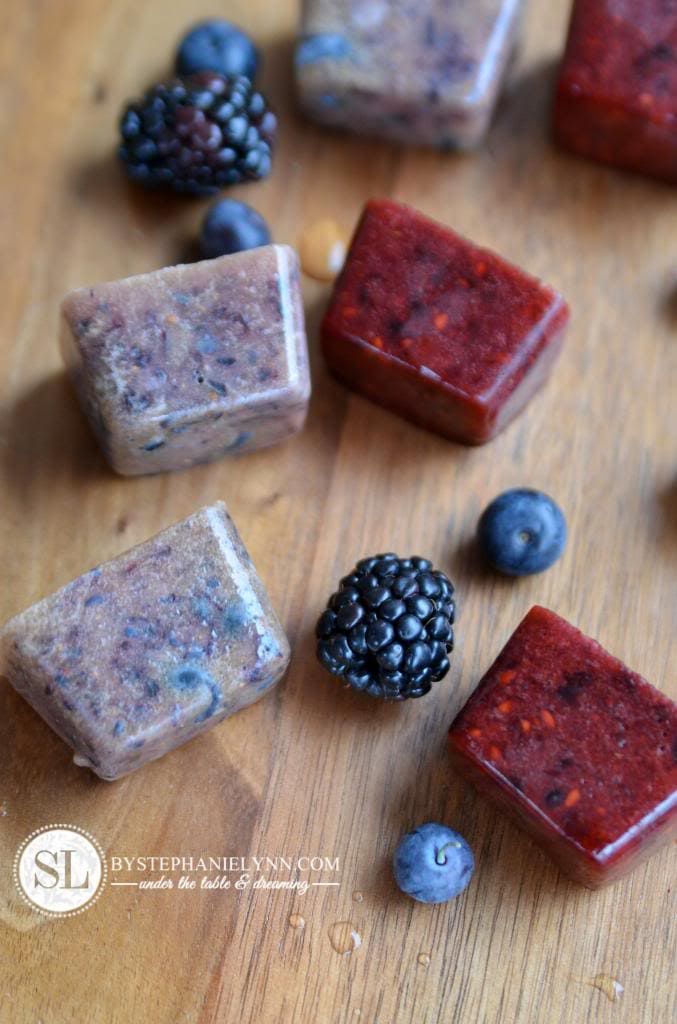 homemade berry ice cubes on a wood counter 