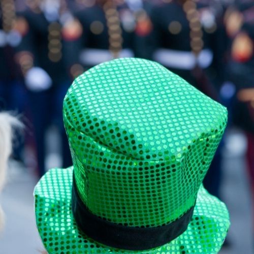 close up of green sequin hat with parade in background