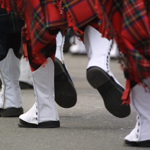 marching feet in white boots and kilts
