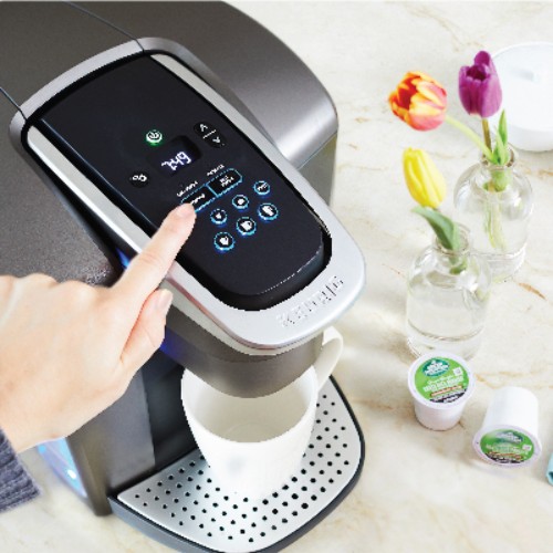 pushing brew button on Keurig coffee maker