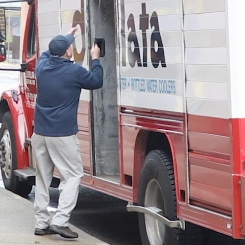 Distillata driver closing the bay doors on delivery truck