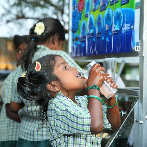 children filling water bottles from planet water filtration system