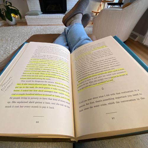 Book laying open on lap with pages highlited.