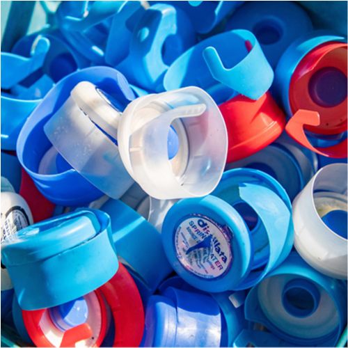 Blue, red, and clear 5-gallon water bottle caps collected for recycling.